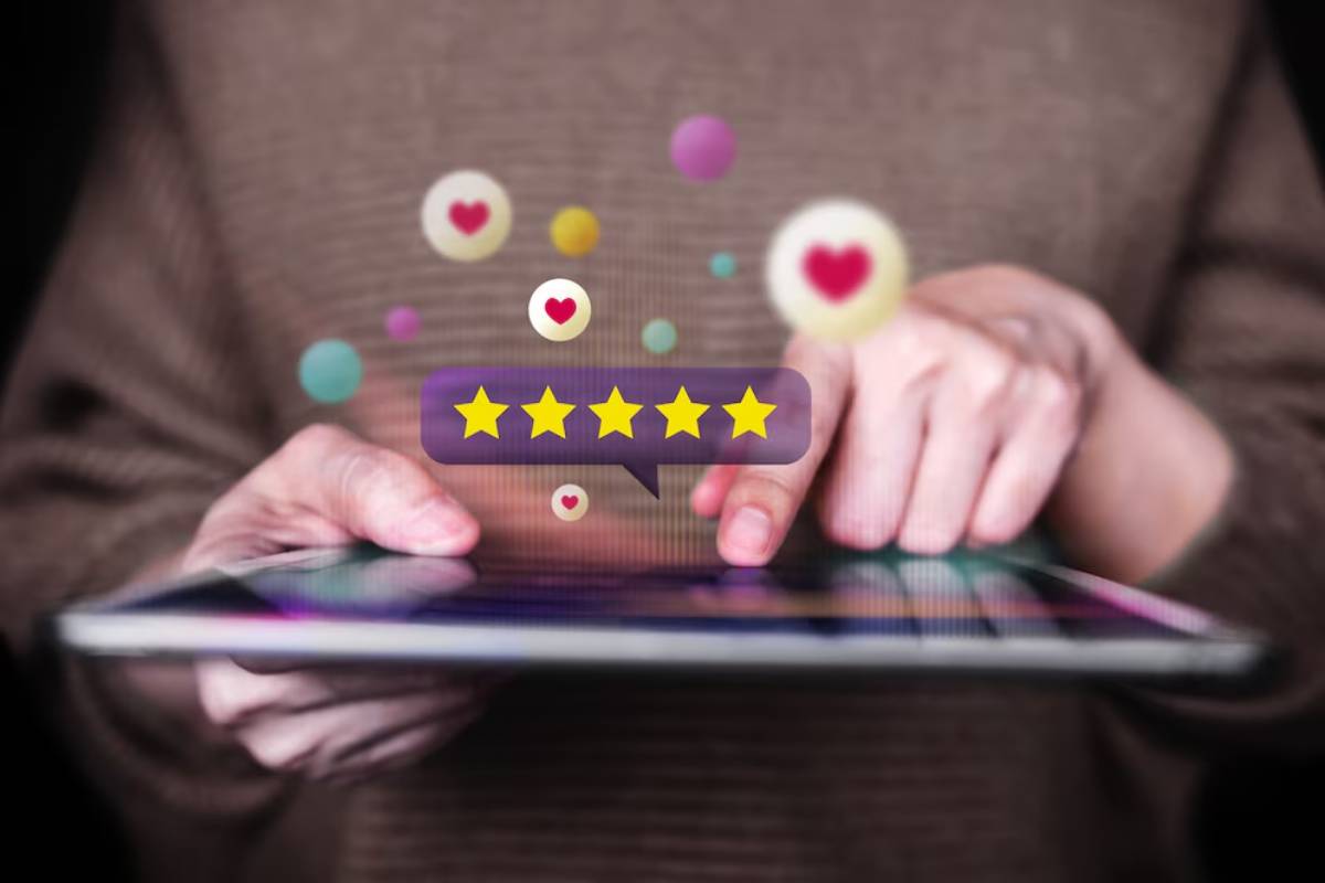 Person using a tablet displaying a five-star review and various social media reactions.