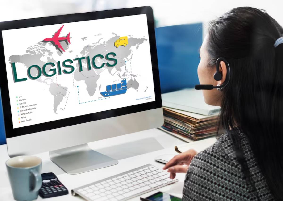 Woman with headset views a logistics map on a computer screen.