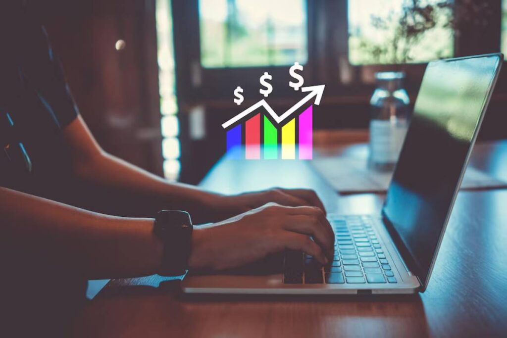 Person using a laptop with colorful financial graph icons representing growth, indicating business analytics or financial planning.